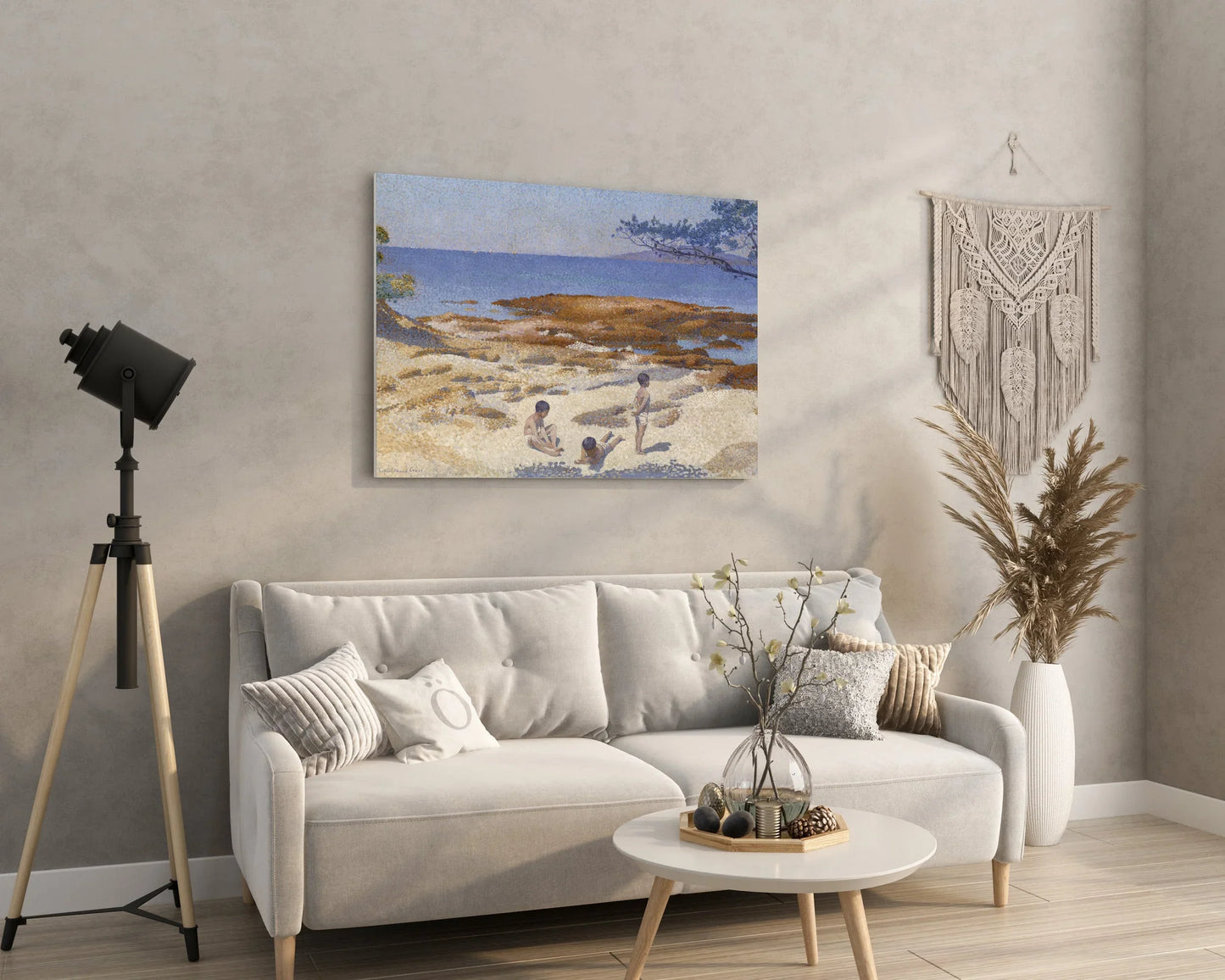 Cozy living room with beach canvas art, modern sofa, macrame wall hanging, and minimalist decor.